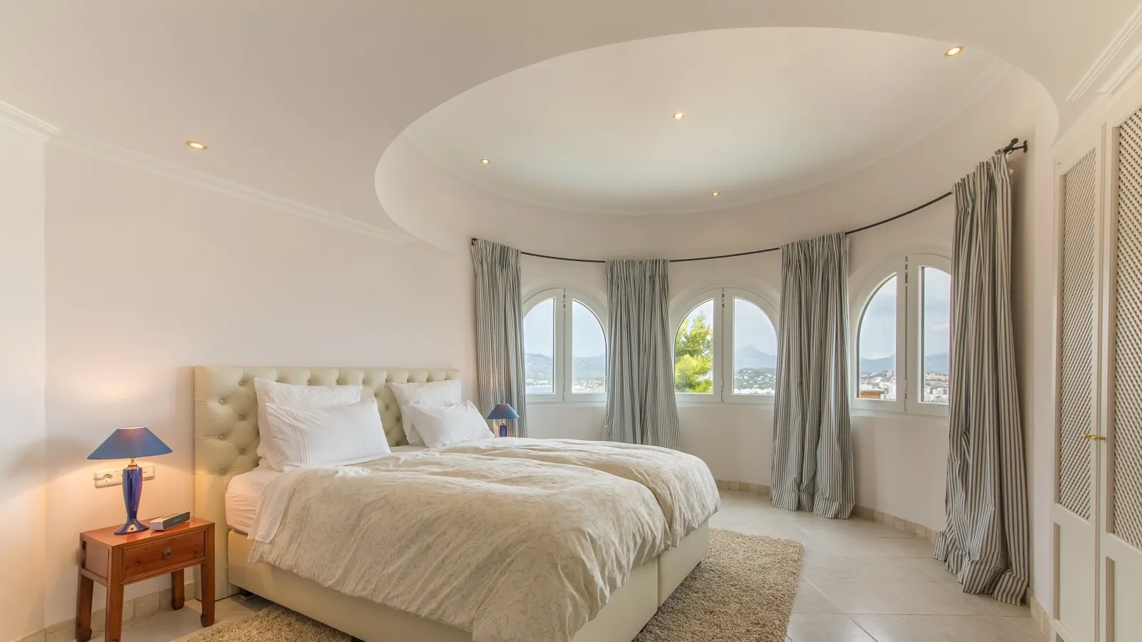Ein Schlafzimmer mit Kingsize-Bett, Morgenlicht durch die Vorhänge
